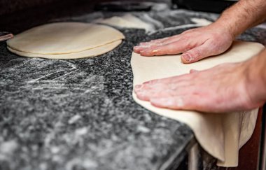 Şef fırıncının eli mutfakta pizza yapıyor. Pizza yapma süreci. İtalyan pizzası pişirmek