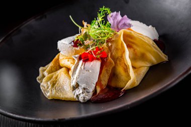 Çilekli krepler reçel ve krem peynirle ahşap masa üzerinde siyah arka plan