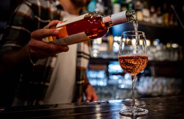 Barmen, kafede ya da barda bardağa kırmızı şarap dolduruyor