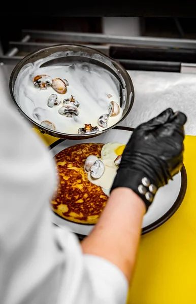 Mãos Chef Luvas Cozinhar Panqueca Frita Com Molho Cogumelos Bacon — Fotografia de Stock
