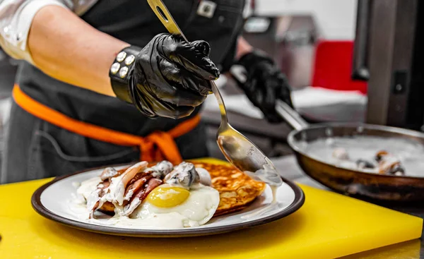 Mãos Chef Luvas Cozinhar Panqueca Frita Com Molho Cogumelos Bacon Imagem De Stock