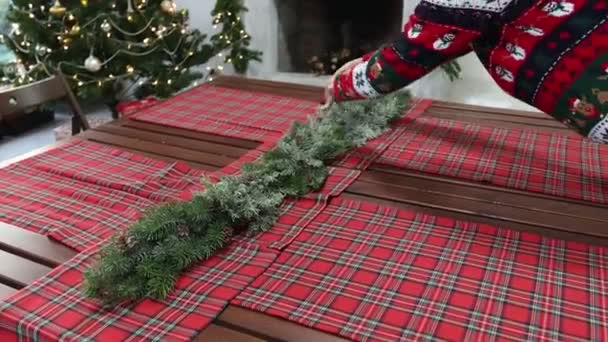 Jeune femme en pull avec un motif de Noël décoré la table du Nouvel An — Video