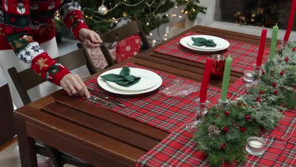 Jeune femme en pull avec un motif de Noël décoré la table du Nouvel An — Video