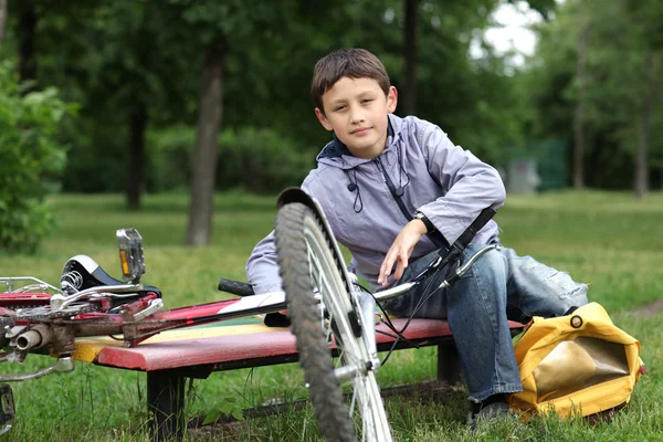 Young boy with bicycle relaxing outdoors Royalty Free Stock Photos