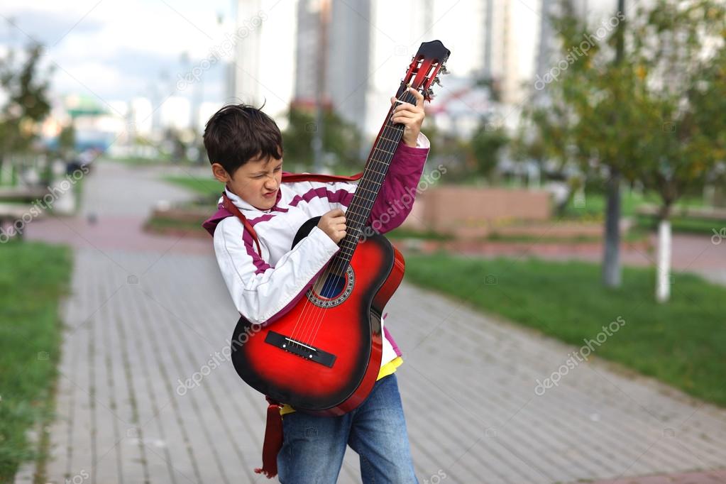 Boy playing the guitar outdoors