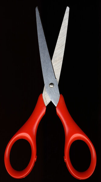 Red scissors against a black background color