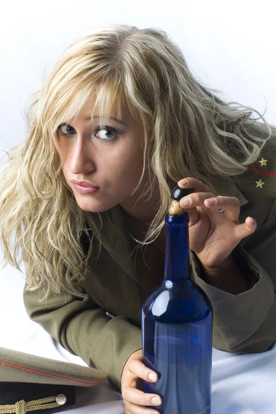 金发女郎以旧军事形式与葡萄酒瓶 — 图库照片