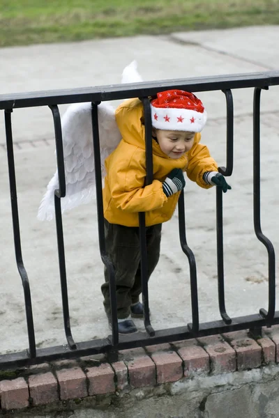 Menino anjo no chapéu de Natal ao ar livre — Fotografia de Stock