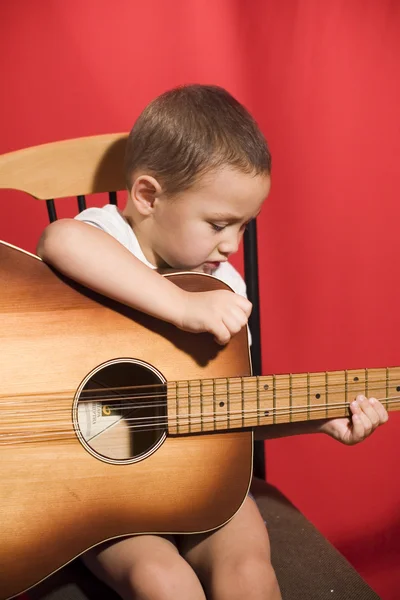 Mały student muzyki, gry na gitarze — Zdjęcie stockowe