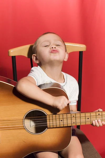 Mały student muzyki, gry na gitarze — Zdjęcie stockowe