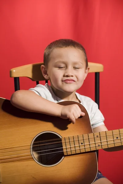 Mały student muzyki, gry na gitarze — Zdjęcie stockowe