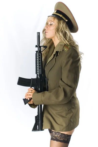 Sexy blondie in black stokings and old soviet military uniform holding an automatic rifle — Stock Photo, Image