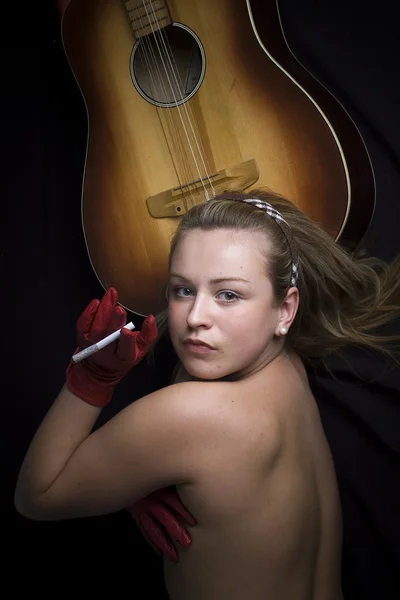 Schöne oben ohne blonde Mädchen mit Gitarre und Zigarette — Stockfoto