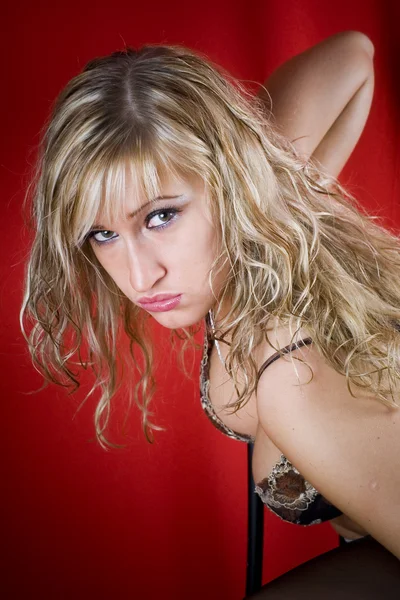 Porträt einer blonden Frau auf rotem Hintergrund — Stockfoto