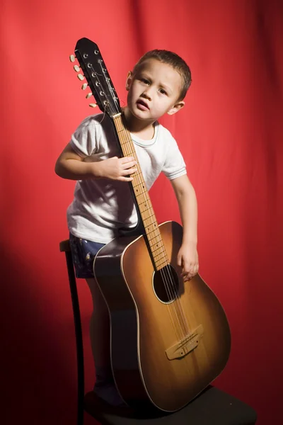 Mały student muzyki, gry na gitarze — Zdjęcie stockowe