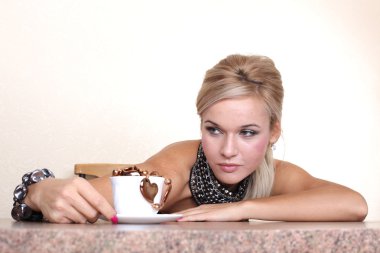 Kadın sarı duvara masada sıcak çikolata ile