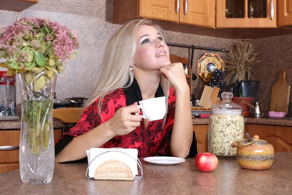 Mujer oliendo la taza de aroma de la bebida caliente, desayuno en el kitc — Foto de Stock