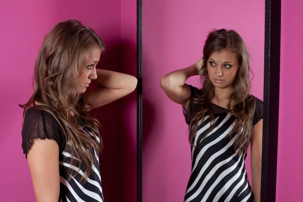 Jonge vrouw op zoek in spiegel — Stockfoto