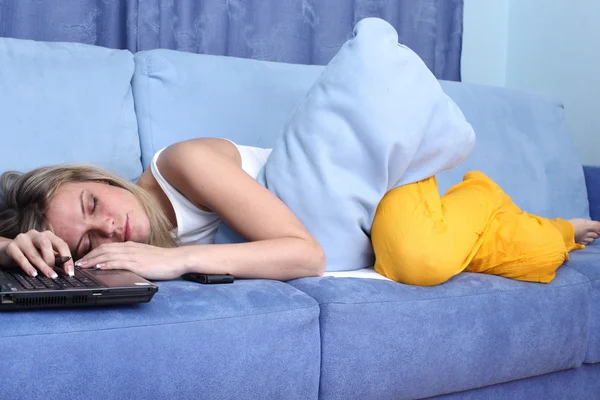 Mujer en sofá azul con portátil —  Fotos de Stock