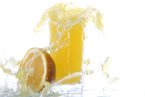 Zitronensaftglas mit Zitronenscheibe, mit Saftspritzer, isoliert auf weißem Hintergrund. — Stockfoto