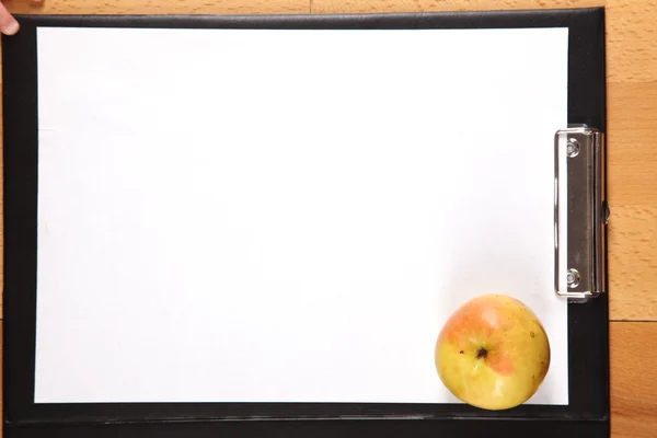 Clipboard e maçã amarela — Fotografia de Stock