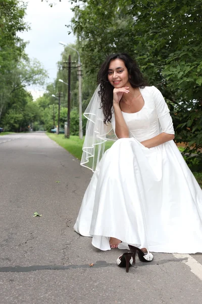 Runaway bride hitch-hiking on a road — Stock Photo, Image