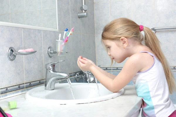 Маленькая девочка стирает в ванной комнате — стоковое фото