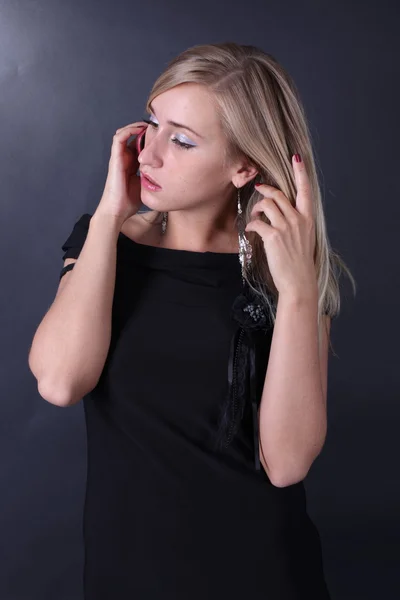 Portrait of the beautiful blonde talking on the phone on a black background — Stock Photo, Image