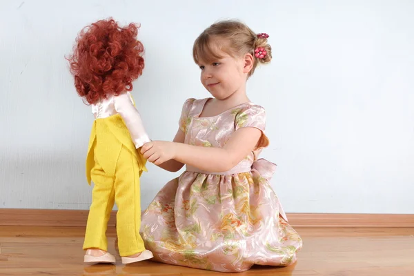 Kleines Mädchen mit Puppe im Zimmer — Stockfoto