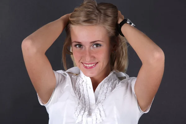 Retrato de una atractiva joven mujer de negocios de pie sobre fondo negro — Foto de Stock