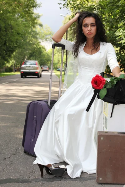 Runaway bride hitch-hiking on a road — Stock Photo, Image