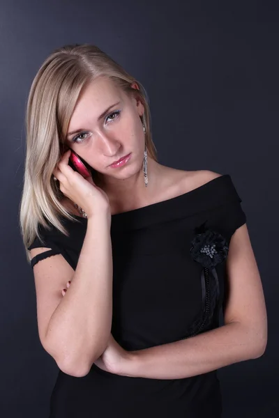 Портрет красивої блондинки, що говорить по телефону на чорному тлі — стокове фото