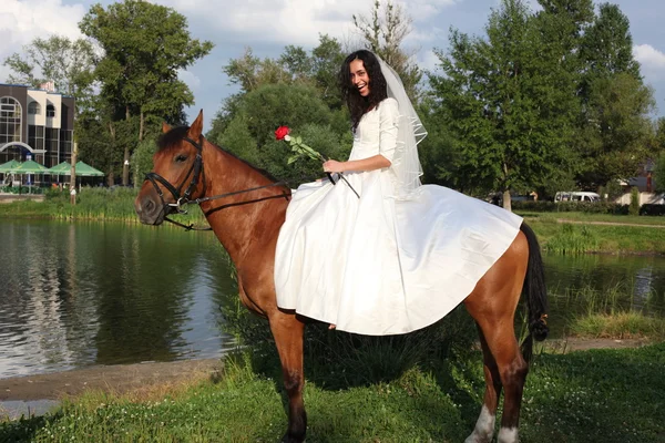 Невеста верхом на коричневой лошади — стоковое фото