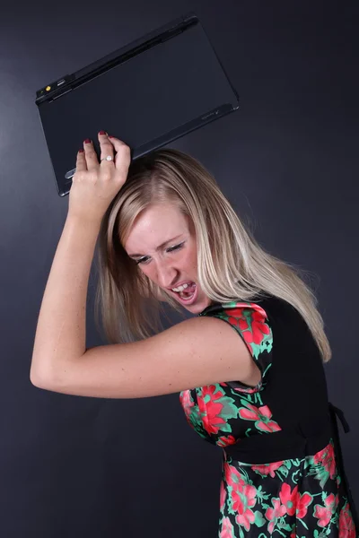 Portret van de mooie blonde met laptop op een zwarte achtergrond — Stockfoto