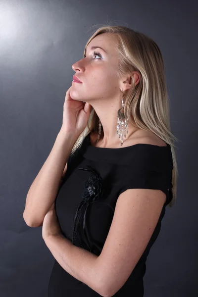 Portrait of the beautiful blonde talking on the phone on a black background — Stock Photo, Image