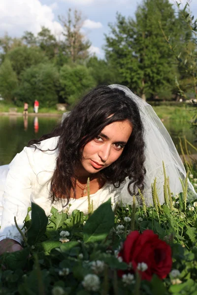 Bruid met een roos in de buurt van het meer — Stockfoto