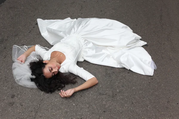 Bela noiva que põe em uma estrada — Fotografia de Stock