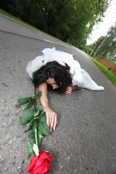 Bela noiva que põe em uma estrada — Fotografia de Stock