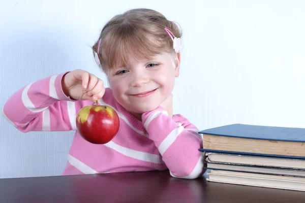 Holčička s apple a knihy — Stock fotografie