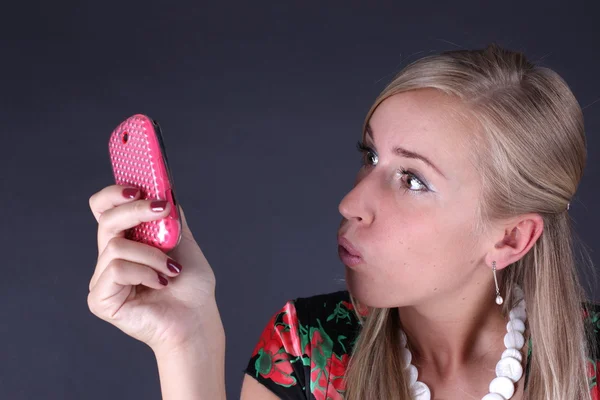 Portrait of the beautiful blonde talking on the phone on a black background — Stock Photo, Image