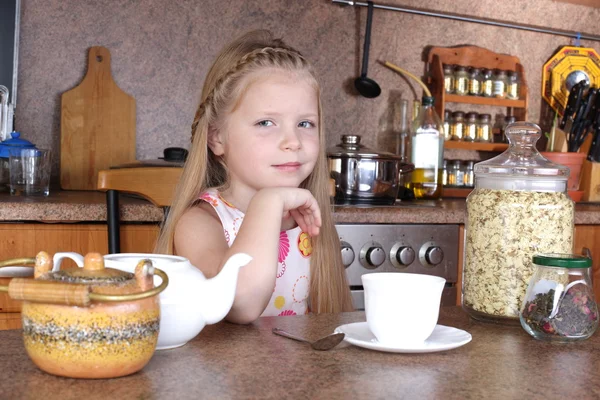 Petite fille boit du thé de tasse à la cuisine — Photo