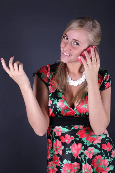 Porträtt av den vackra blonda prata i telefon på en svart bakgrund — Stockfoto