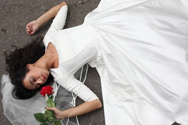 Bela noiva que põe em uma estrada — Fotografia de Stock