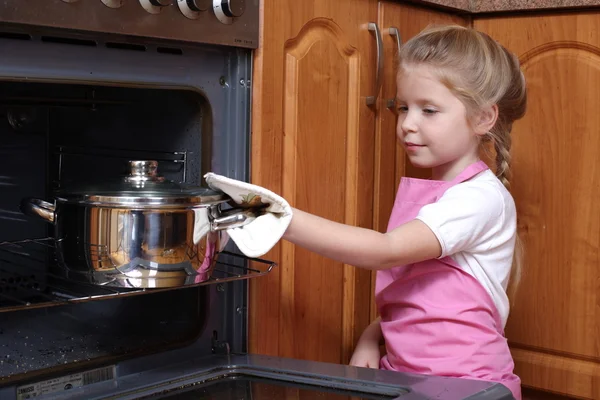 Little girl taken the food out of the kitchen oven — Stock Photo, Image