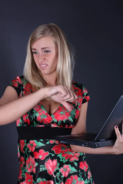 Portret van de mooie blonde met laptop op een zwarte achtergrond — Stockfoto