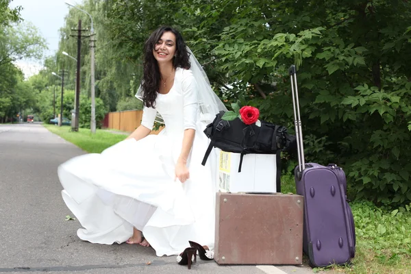 Runaway bride hitch-hiking on a road — Stock Photo, Image
