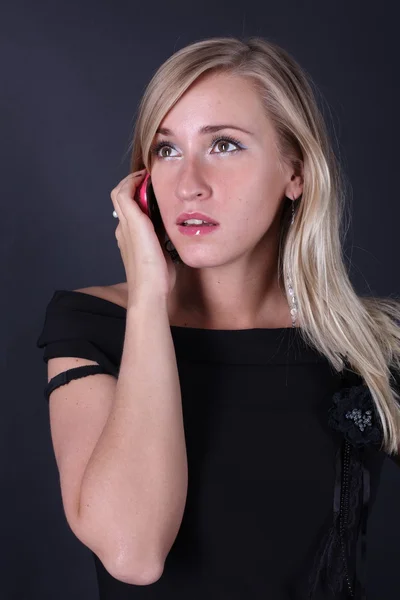 Portrét krásné blondýny mluví po telefonu na černém pozadí — Stock fotografie