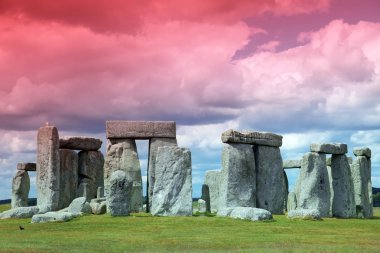 Stonehenge mavi gökyüzünün altında yeşil çimenlerin üzerinde tarihi bir site. stonehen