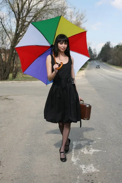 Girl with umbrella on the road — Stock Photo, Image