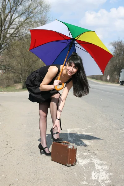 Girl with umbrella on the road — Stock Photo, Image